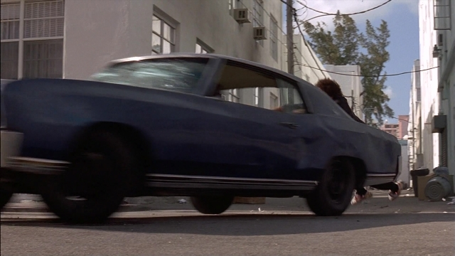 Wide shot frame from Ace Ventura: Pet Detective — walking, street, car