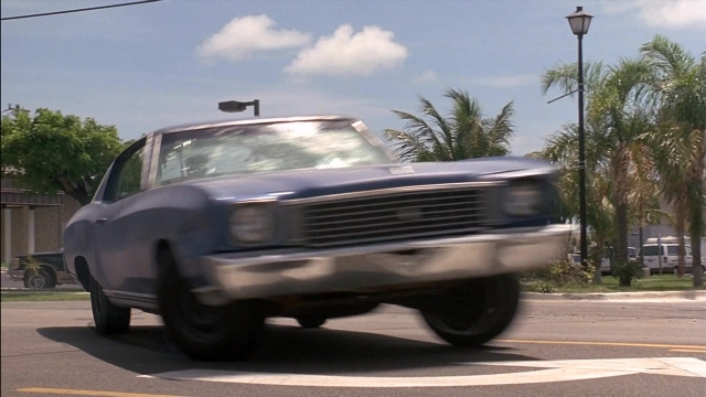 Wide shot frame from Ace Ventura: Pet Detective — door, street, car