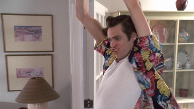 Wide shot frame from Ace Ventura: Pet Detective — standing, room, shirt