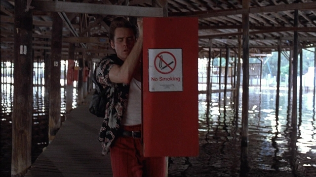 Wide shot frame from Ace Ventura: Pet Detective — standing, shirt, water
