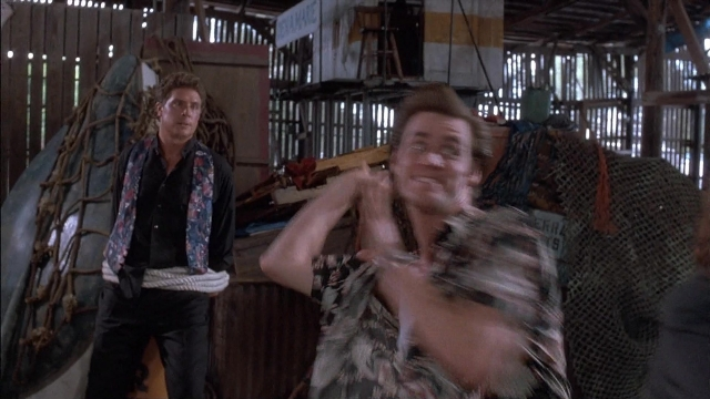 Wide shot frame from Ace Ventura: Pet Detective — coat, hand, shirt