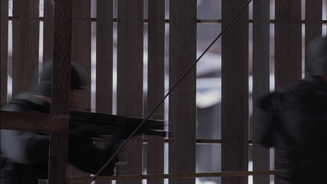 Wide shot frame from Ace Ventura: Pet Detective — hat, gun, face