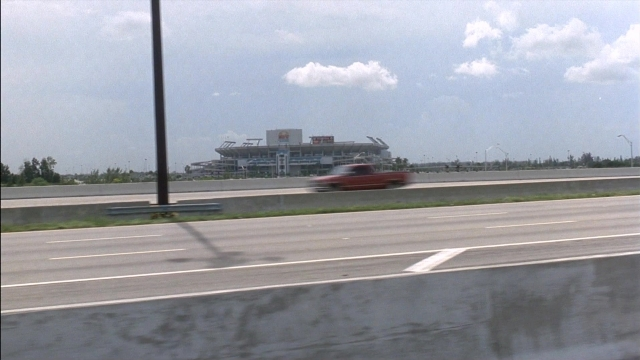 Wide shot frame from Ace Ventura: Pet Detective — car, person