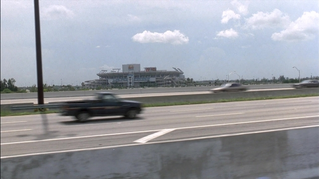 Frame from Ace Ventura: Pet Detective — street, car, truck