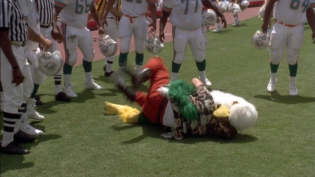 Wide shot frame from Ace Ventura: Pet Detective — standing, uniform, person