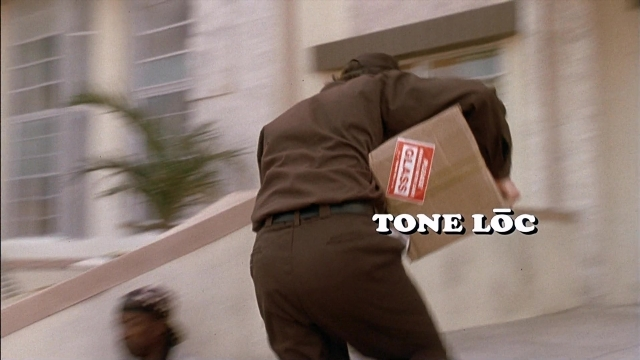 Wide shot frame from Ace Ventura: Pet Detective — walking, street, hand