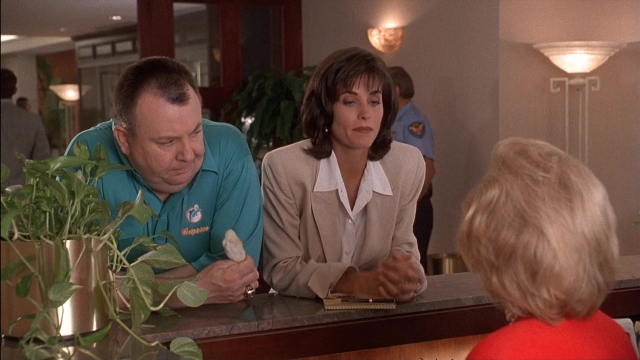 Wide shot frame from Ace Ventura: Pet Detective — sitting, shirt, face
