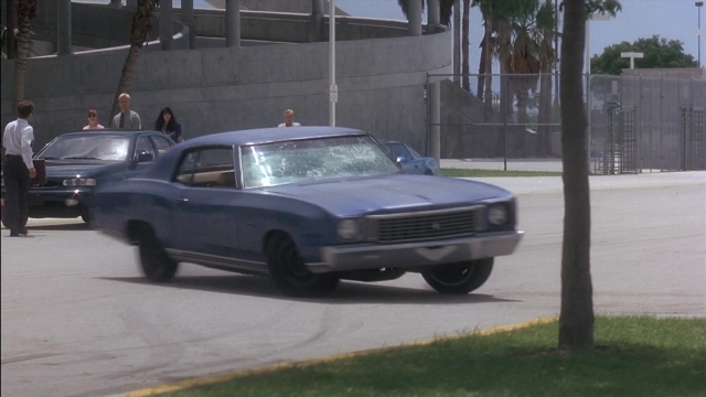 Wide shot frame from Ace Ventura: Pet Detective — walking, street, car