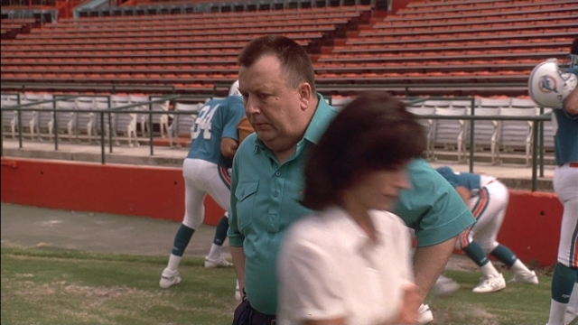 Wide shot frame from Ace Ventura: Pet Detective — standing, hand, shirt