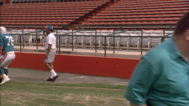 Wide shot frame from Ace Ventura: Pet Detective — walking, hat, shirt