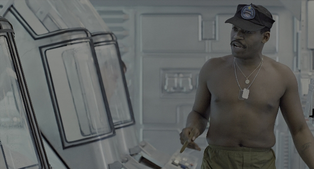 Wide shot frame from Aliens — standing, room, hat