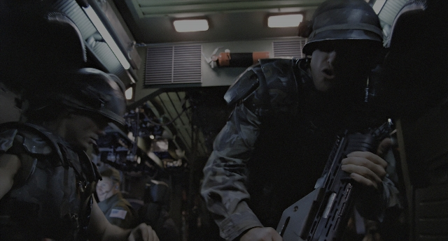 Wide shot frame from Aliens — standing, car, night