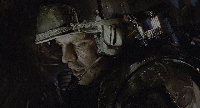 Wide shot frame from Aliens — hat, hand, gun