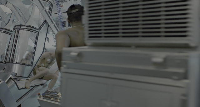 Wide shot frame from Aliens — sitting, room, person