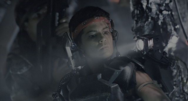 Wide shot frame from Aliens — hand, gun, face