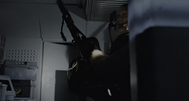 Wide shot frame from Aliens — standing, room, hand