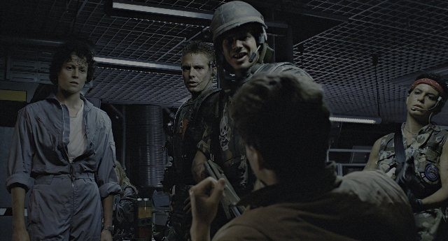 Wide shot frame from Aliens — sitting, standing, room