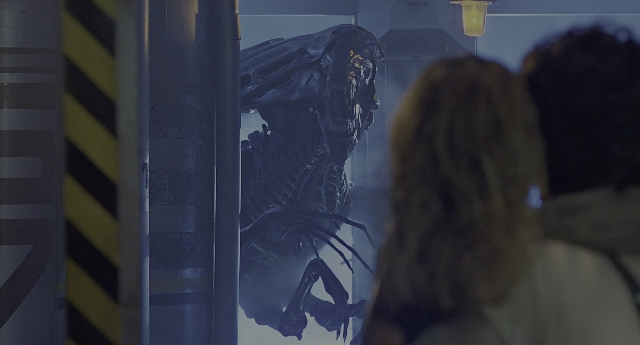 Wide shot frame from Aliens — standing, room, door