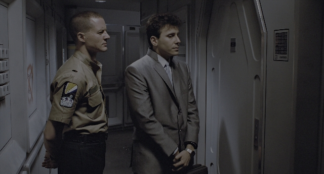 Wide shot frame from Aliens — standing, uniform, hand