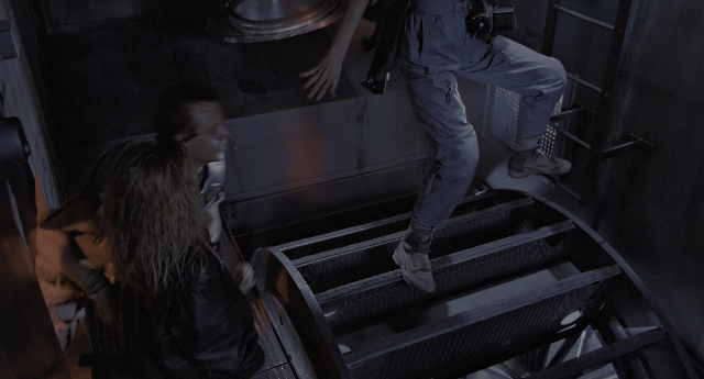 Wide shot frame from Aliens — standing, room, person