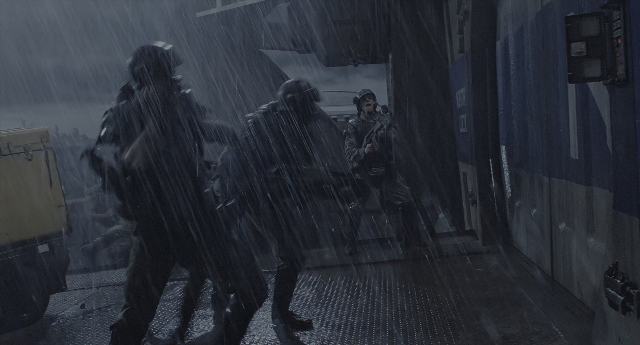 Wide shot frame from Aliens — walking, door, rain