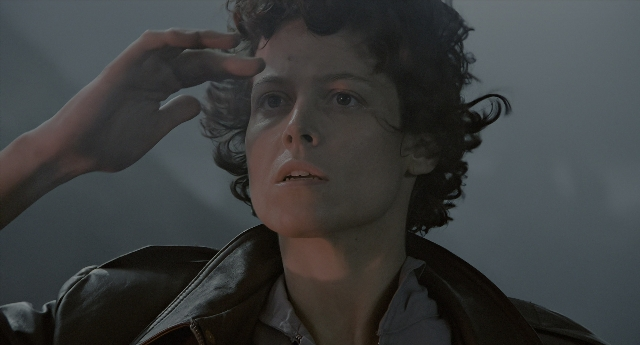 Medium shot frame from Aliens — hand, shirt, face