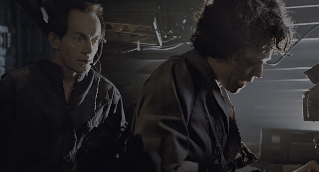 Wide shot frame from Aliens — room, suit, tie