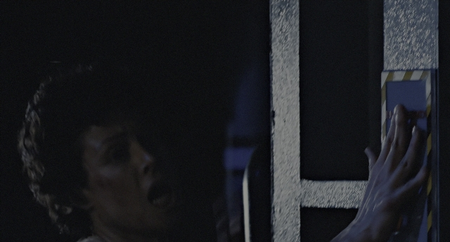 Wide shot frame from Aliens — door, hand, face