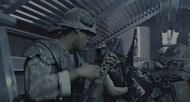 Wide shot frame from Aliens — standing, room, car