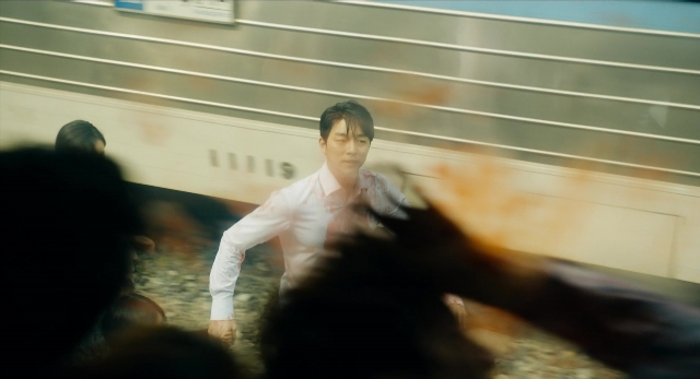Wide shot frame from Busanhaeng — standing, shirt, train
