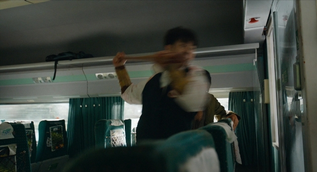 Wide shot frame from Busanhaeng — standing, car, hand