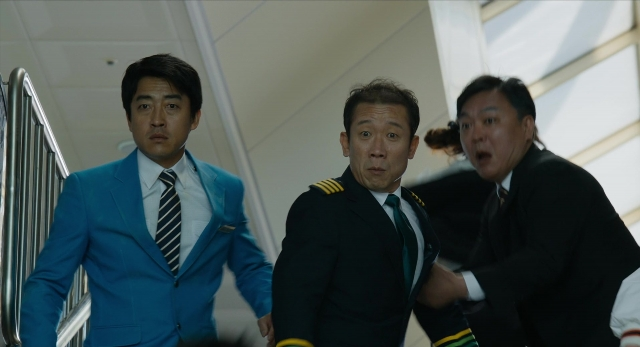 Wide shot frame from Busanhaeng — walking, suit, tie