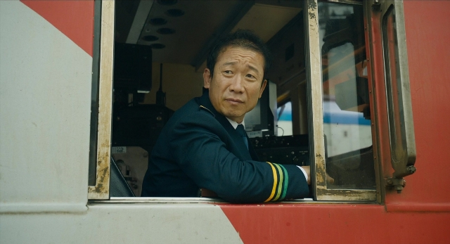 Wide shot frame from Busanhaeng — sitting, face, train