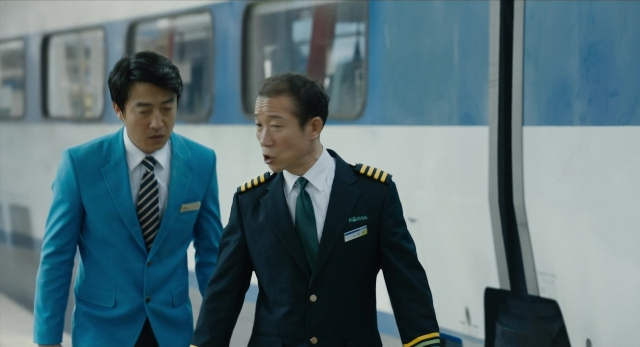 Wide shot frame from Busanhaeng — walking, suit, tie