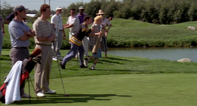 Wide shot frame from Happy Gilmore — standing, shirt, bag