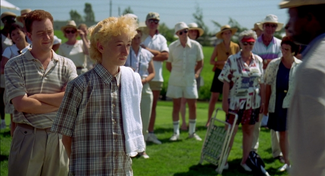 Wide shot frame from Happy Gilmore — standing, dialogue, suit
