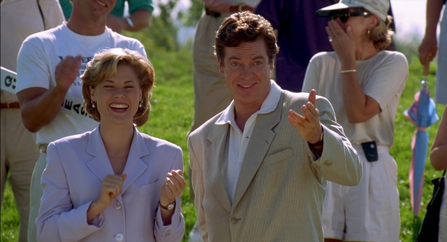 Wide shot frame from Happy Gilmore — standing, suit, hair
