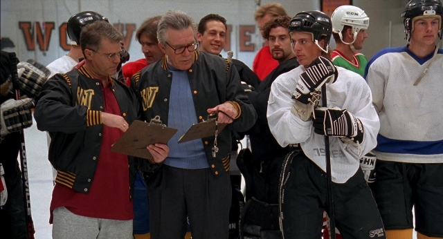 Wide shot frame from Happy Gilmore — standing, hat, person