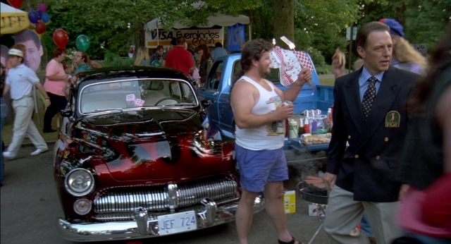 Wide shot frame from Happy Gilmore — dialogue, street, hat