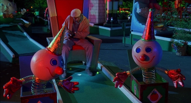 Wide shot frame from Happy Gilmore — sitting, standing, table