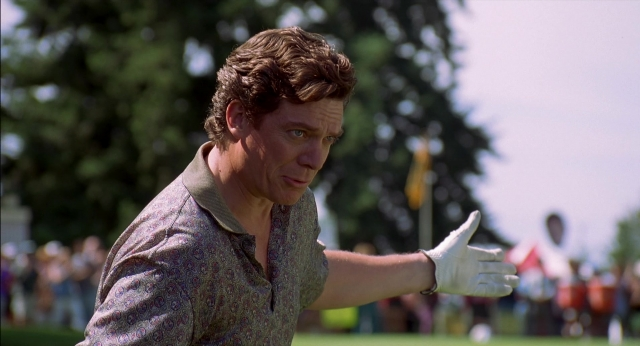 Wide shot frame from Happy Gilmore — shirt, hair, glove