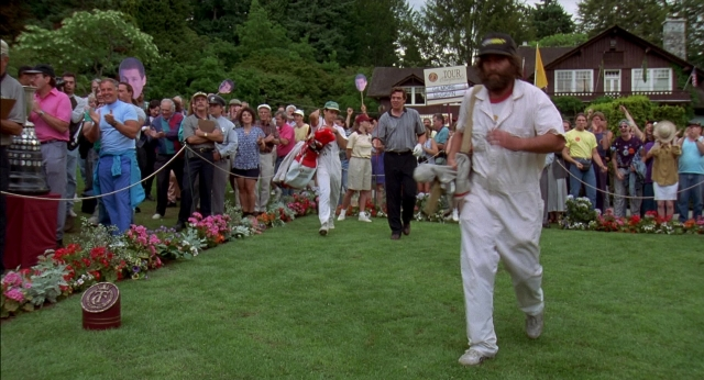 Wide shot frame from Happy Gilmore — walking, hat, suit