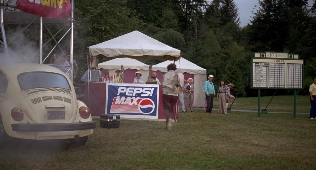 Wide shot frame from Happy Gilmore — standing, car, tent
