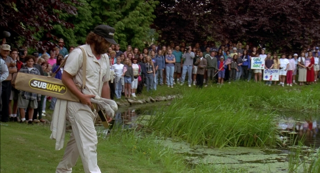 Wide shot frame from Happy Gilmore — walking, hat, shirt