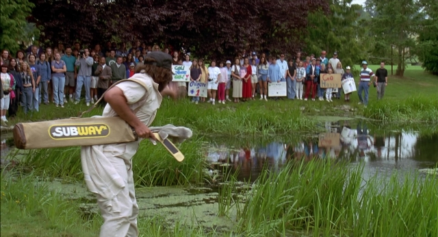 Wide shot frame from Happy Gilmore — standing, hand, shirt