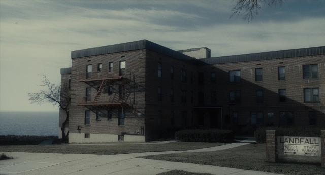 Wide shot frame from Inside Llewyn Davis — fire, house, sea