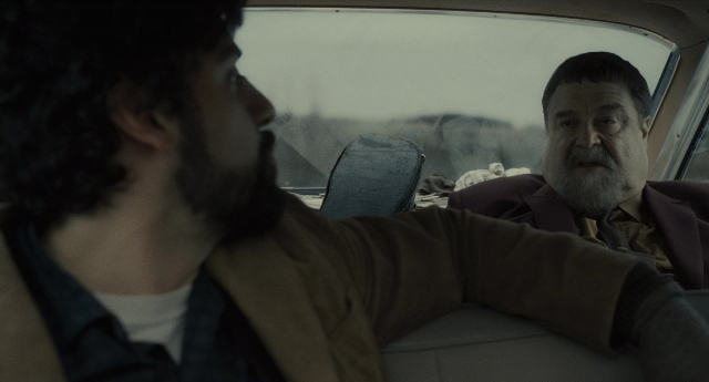 Wide shot frame from Inside Llewyn Davis — sitting, car, suit