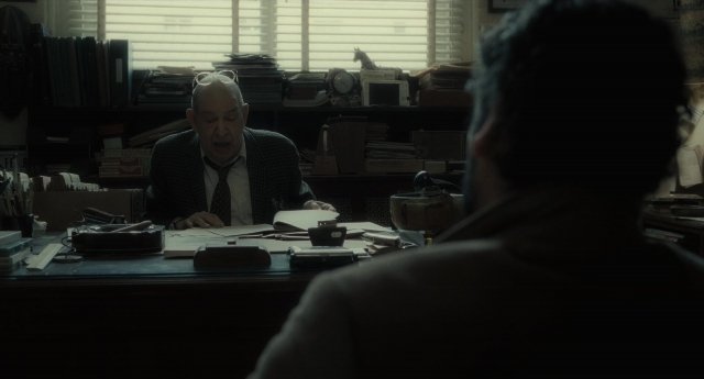 Wide shot frame from Inside Llewyn Davis — sitting, room, table