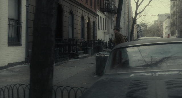 Wide shot frame from Inside Llewyn Davis — walking, street, car