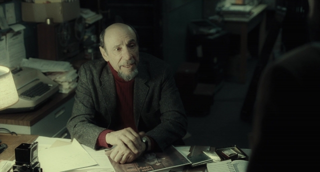 Wide shot frame from Inside Llewyn Davis — sitting, shirt, office